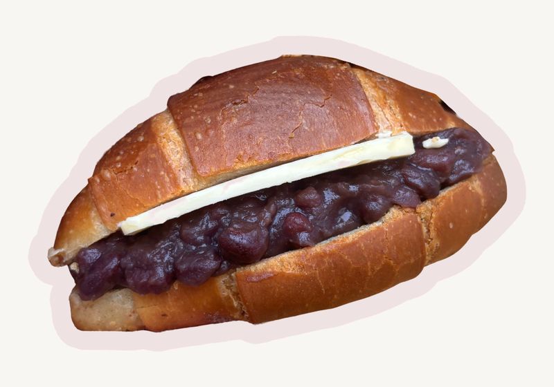 Shio pan split and filled with red bean paste and a slab of butter, topped with black sesame