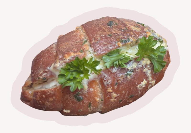Scored shio pan filled with garlic cream cheese and fresh parsley