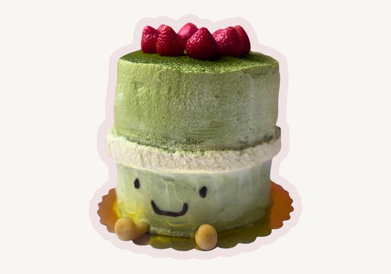 Matcha Jellycat celebration cake with a smiling face, marzipan feet and strawberries